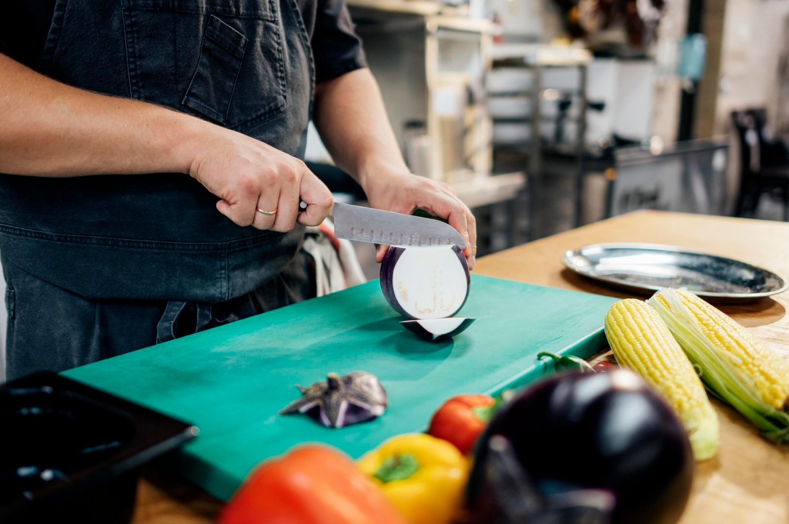 male-chef-slicing-aubergine-kitchen-scaled.jpg